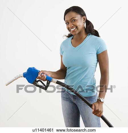 African American young adult female holding gas pump and smiling. View Large Photo Image Stock Image - African American young adult female holding gas pump and smiling.. Fotosearch