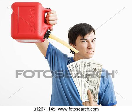 Asian young man holding gas can pouring gasoline onto money. View Large Photo Image Stock Photography - Asian young man holding gas can pouring gasoline onto money.. Fotosearch