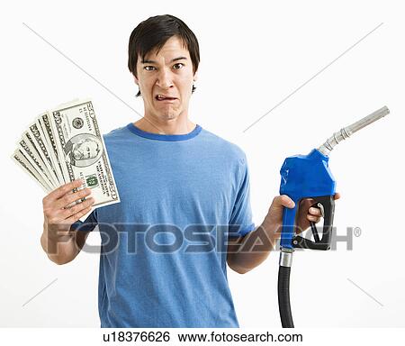 Asian young man with confused expression holding money and gas pump nozzle. View Large Photo Image Stock Photograph - Asian young man with confused expression holding money and gas pump nozzle.. Fotosearch