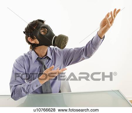 Businessman sitting in white room wearing gas mask gesturing to unknown person View Large Photo Image Stock Photo - Businessman sitting in white room wearing gas mask gesturing to unknown person. Fotosearch