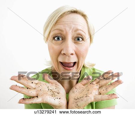 Exasperated adult blonde woman with hands covered in dirt. View Large Photo Image Stock Image - Exasperated adult blonde woman with hands covered in dirt.. Fotosearch