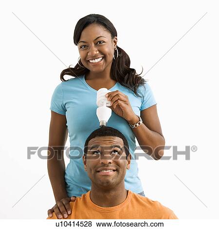 Female holding light bulb over man's head View Large Photo Image Stock Photo - Female holding light bulb over man's head. Fotosearch