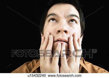 Portrait of Asian young man with hands on face looking up. View Large Photo Image Stock Image - Portrait of Asian young man with hands on face looking up.. Fotosearch
