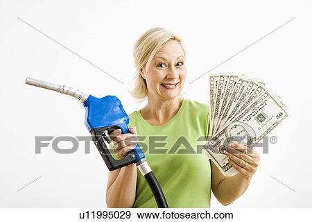 Stock Photo - Portrait of smiling adult blonde woman holding gas nozzle and lots of money. Fotosearch