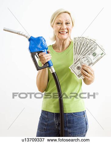 Stock Photo - Portrait of smiling adult blonde woman holding gas nozzle and lots of money.. Fotosearch