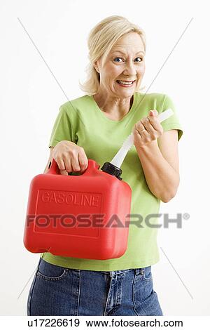 Stock Photo - Portrait of smiling adult blonde woman holding gas can.. Fotosearch