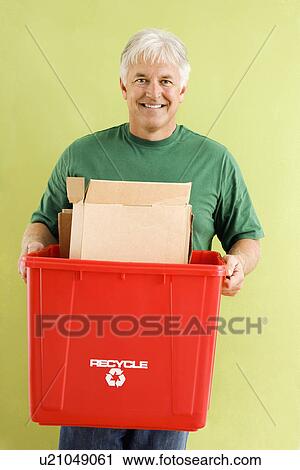 Portrait of smiling adult man holding recycling bin full of cardboard View Large Photo Image Stock Image - Portrait of smiling adult man holding recycling bin full of cardboard. Fotosearch