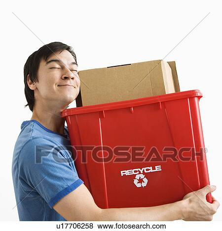 Portrait of smiling Asian young man holding recycling bin. View Large Photo Image Stock Photo - Portrait of smiling Asian young man holding recycling bin.. Fotosearch
