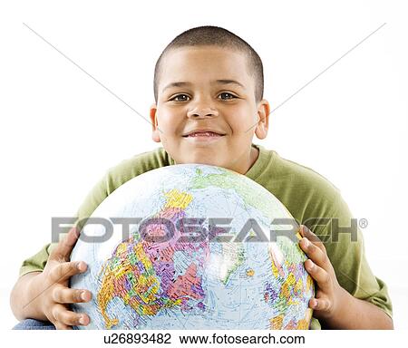 Stock Image - Young latino adolescent boy holding globe.. Fotosearch