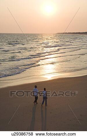 Aerial of couple holding hands and walking on beach on Bald Head Island, North Carolina View Large Photo Image Stock Photo - Aerial of couple holding hands and walking on beach on Bald Head Island, North Carolina. Fotosearch