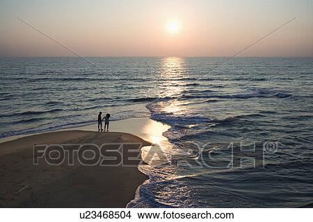 Aerial view of couple on beach in Bald Head Island, North Carolina during sunset View Large Photo Image Picture - Aerial view of couple on beach in Bald Head Island, North Carolina during sunset. Fotosearch