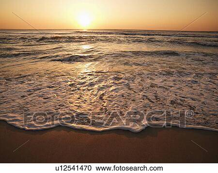 Crashing waves with sun setting View Large Photo Image Stock Image - Crashing waves with sun setting. Fotosearch