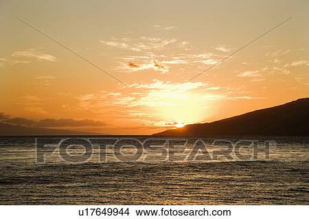 Sun setting behind island off Maui, Hawaii View Large Photo Image Picture - Sun setting behind island off Maui, Hawaii. Fotosearch
