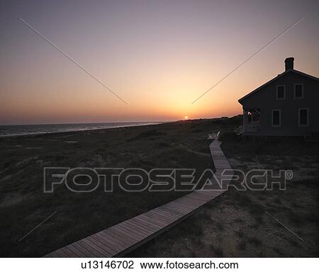 Sunset over coastal beach house with wooden boardwalk at Bald Head Island, North Carolina. View Large Photo Image Stock Image - Sunset over coastal beach house with wooden boardwalk at Bald Head Island, North Carolina.. Fotosearch