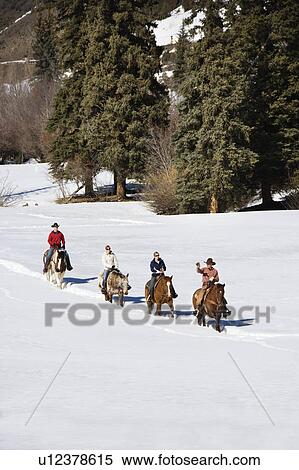 Four people horseback riding in snow covered landscape in Colorado, USA. View Large Photo Image Stock Photography - Four people horseback riding in snow covered landscape in Colorado, USA.. Fotosearch