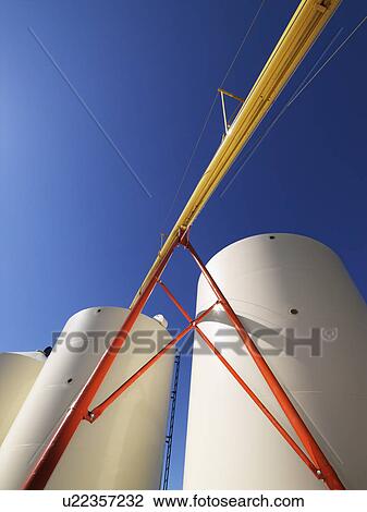 Low angle view of metal grain storage silos against blue background View Large Photo Image Stock Image - Low angle view of metal grain storage silos against blue background. Fotosearch