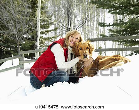 Woman hugging dog and smiling in snow covered Colorado landscape. View Large Photo Image Stock Photography - Woman hugging dog and smiling in snow covered Colorado landscape.. Fotosearch