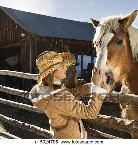 Woman petting horse with stable View Large Photo Image Stock Photography - Woman petting horse with stable. Fotosearch