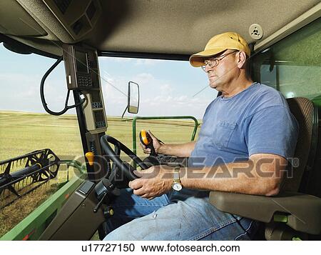 Farmer driving combine and harvesting crop View Large Photo Image Stock Image - Farmer driving combine and harvesting crop. Fotosearch