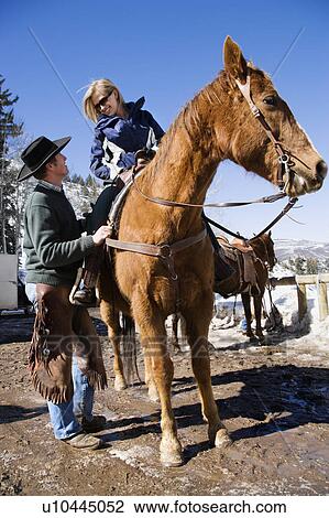 Wrangler talking to young woman on horseback. View Large Photo Image Stock Image - Wrangler talking to young woman on horseback.. Fotosearch