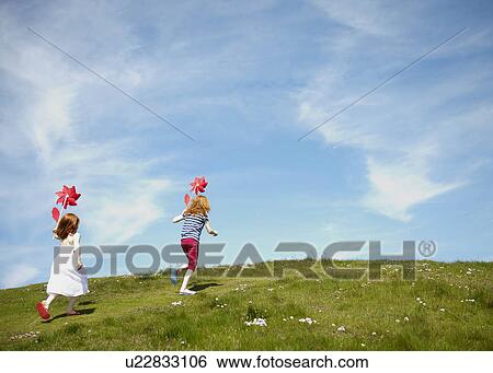 2 girls running in field with windmills View Large Photo Image Stock Photograph - 2 girls running in field with windmills. Fotosearch