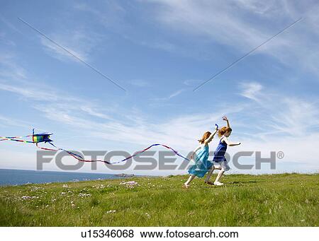 2 girls running with kites in field View Large Photo Image Stock Photo - 2 girls running with kites in field. Fotosearch
