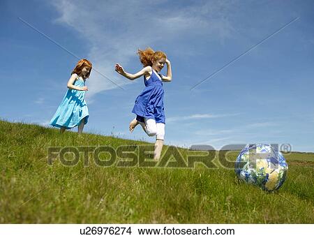 2 young girls running with ball (globe) View Large Photo Image Picture - 2 young girls running with ball (globe). Fotosearch