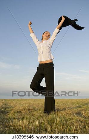 Business woman in a field with arms up View Large Photo Image Stock Photograph - Business woman in a field with arms up. Fotosearch