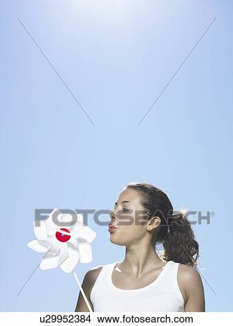 Girl blowing windmill in sun View Large Photo Image Picture - Girl blowing windmill in sun. Fotosearch
