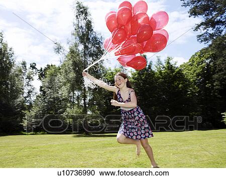Girl holding bunch of red balloons View Large Photo Image Stock Image - Girl holding bunch of red balloons. Fotosearch