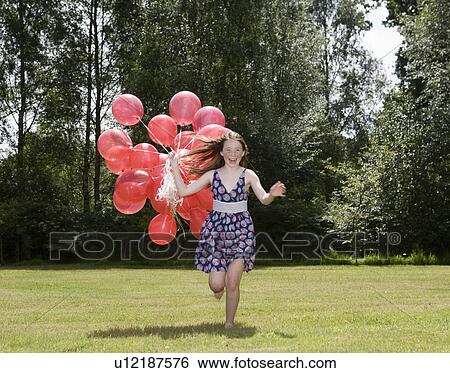 Girl holding bunch of red balloons View Large Photo Image Stock Photograph - Girl holding bunch of red balloons. Fotosearch