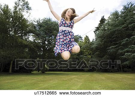 Girl jumping in garden View Large Photo Image Stock Photography - Girl jumping in garden. Fotosearch