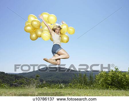 Girl jumping with balloons View Large Photo Image Stock Photo - Girl jumping with balloons. Fotosearch