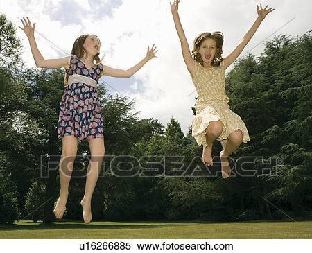 Girls jumping in garden View Large Photo Image Stock Photography - Girls jumping in garden. Fotosearch