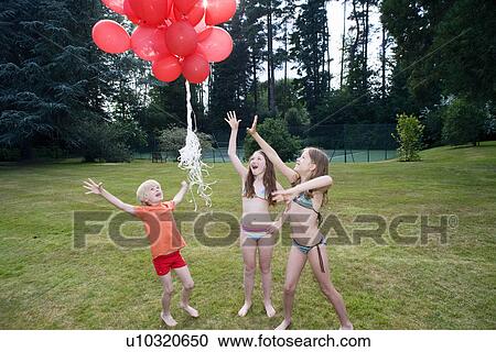 Kids letting go red balloons View Large Photo Image Stock Image - Kids letting go red balloons. Fotosearch