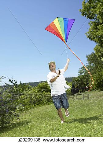 Man running with kite View Large Photo Image Stock Photograph - Man running with kite. Fotosearch
