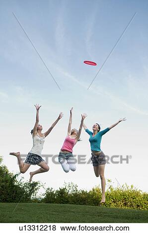 Teenage girls jump to catch a frisbee View Large Photo Image Stock Photo - Teenage girls jump to catch a frisbee. Fotosearch