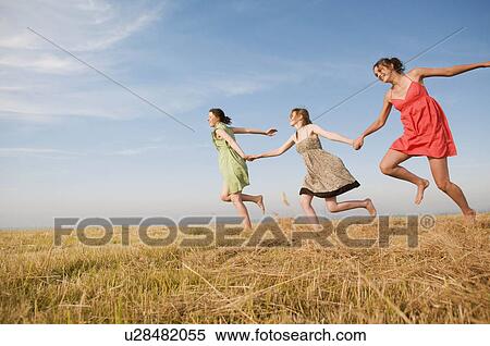 Teenage girls running across a hay field View Large Photo Image Stock Photography - Teenage girls running across a hay field. Fotosearch
