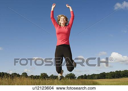 Woman jumping in field View Large Photo Image Picture - Woman jumping in field. Fotosearch