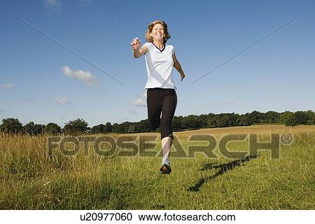 Woman running in field View Large Photo Image Stock Image - Woman running in field. Fotosearch