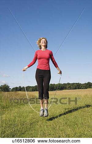 Woman skipping in field View Large Photo Image Stock Photograph - Woman skipping in field. Fotosearch
