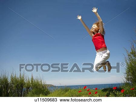 Young girl jumping with arms up View Large Photo Image Stock Image - Young girl jumping with arms up. Fotosearch