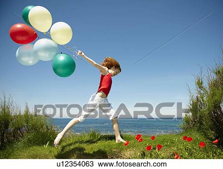 Young girl running with balloons View Large Photo Image Stock Image - Young girl running with balloons. Fotosearch