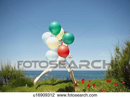 Young girl running with balloons View Large Photo Image Stock Image - Young girl running with balloons. Fotosearch