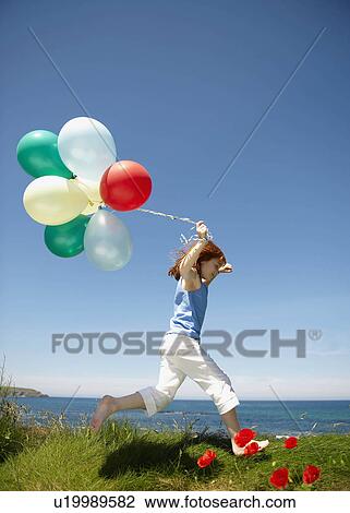 Young girl running with balloons View Large Photo Image Stock Image - Young girl running with balloons. Fotosearch
