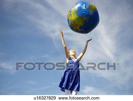 Young girl throwing inflatable globe View Large Photo Image Stock Photo - Young girl throwing inflatable globe. Fotosearch