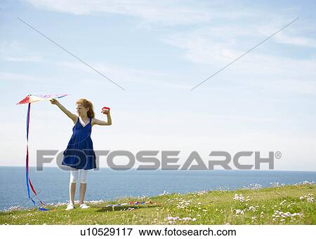 Young girl with kite by ocean View Large Photo Image Stock Photo - Young girl with kite by ocean. Fotosearch