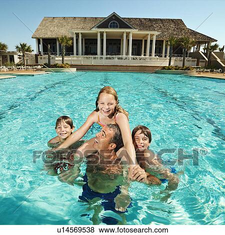 Stock Photo - Family at pool with clubhouse in background. Fotosearch