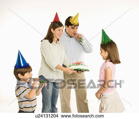 Family celebrating girl's birthday with cake. View Large Photo Image Picture - Family celebrating girl's birthday with cake.. Fotosearch