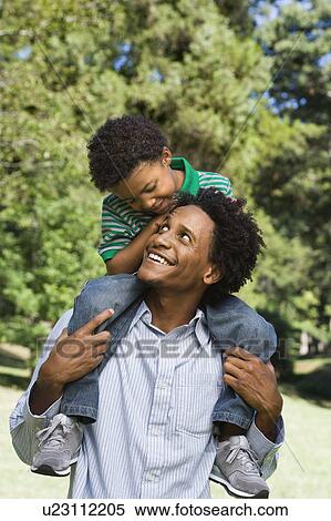 Father carrying son on shoulders in park. View Large Photo Image Stock Photography - Father carrying son on shoulders in park.. Fotosearch